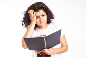 confused-looking woman holding a notebook